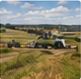 Related-story thumbnail showing patchwork prairie farmland and distant hills beneath a blue sky.